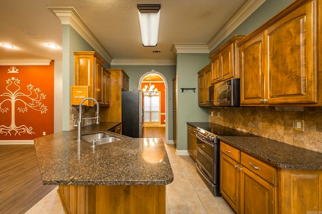 kitchen featuring appliances with stainless steel finishes, light wood-type flooring, a textured ceiling, ornamental molding, and sink