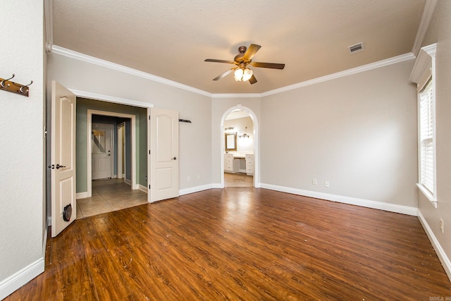 empty room featuring ceiling fan, hardwood / wood-style flooring, ornamental molding, and a textured ceiling