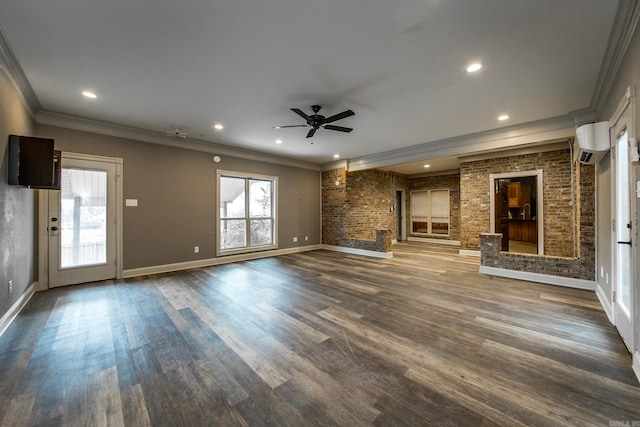 unfurnished living room with wood-type flooring, crown molding, a wall mounted AC, a large fireplace, and ceiling fan