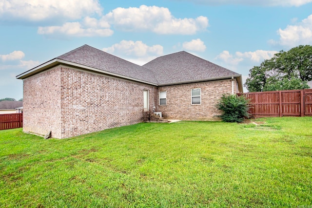 rear view of property featuring a lawn