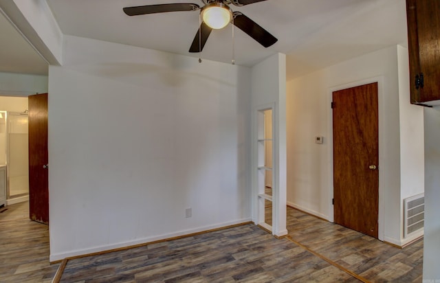 spare room featuring dark hardwood / wood-style flooring and ceiling fan