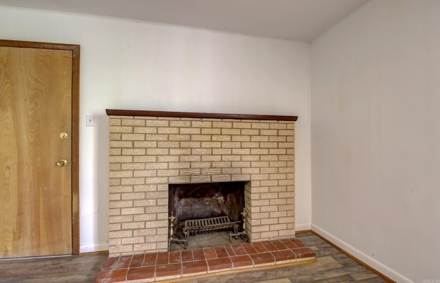 details featuring wood-type flooring, ornamental molding, and a brick fireplace