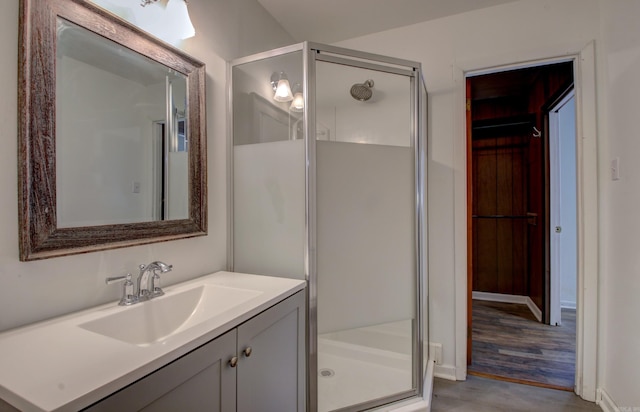 bathroom with vanity, hardwood / wood-style flooring, and a shower with shower door