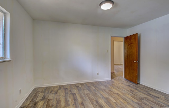 unfurnished room with wood-type flooring