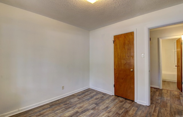 unfurnished room featuring a textured ceiling and dark wood-type flooring