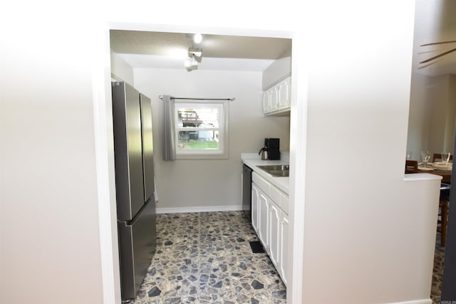 kitchen with white cabinetry and stainless steel fridge