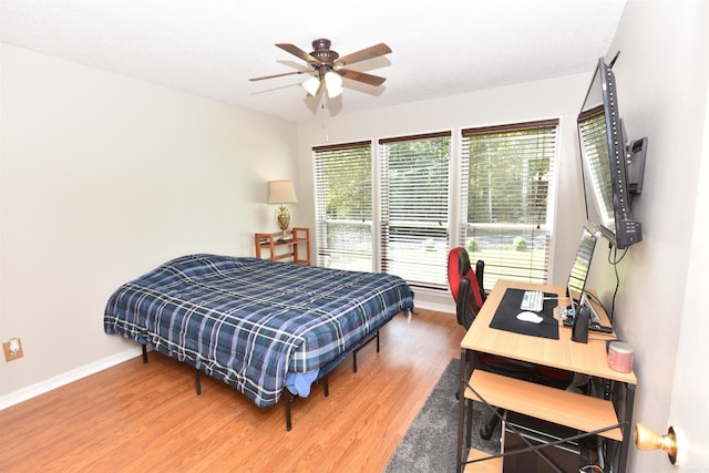 bedroom featuring ceiling fan, hardwood / wood-style flooring, and a textured ceiling