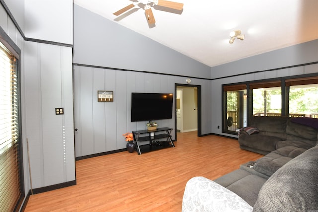 living room with light hardwood / wood-style flooring, vaulted ceiling, and ceiling fan