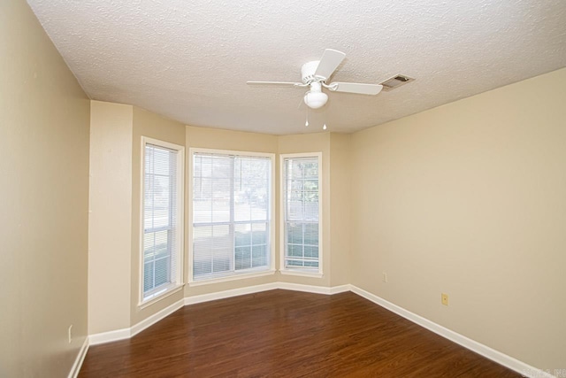 unfurnished room featuring a textured ceiling, dark hardwood / wood-style flooring, and ceiling fan