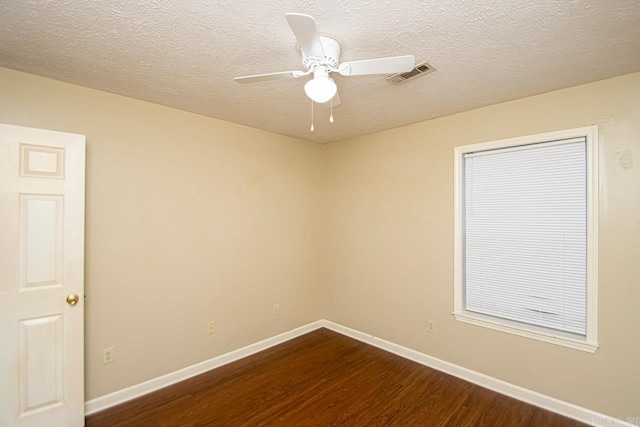 spare room with ceiling fan, dark wood-type flooring, and a textured ceiling