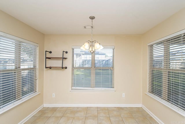 unfurnished dining area featuring an inviting chandelier and light tile patterned floors