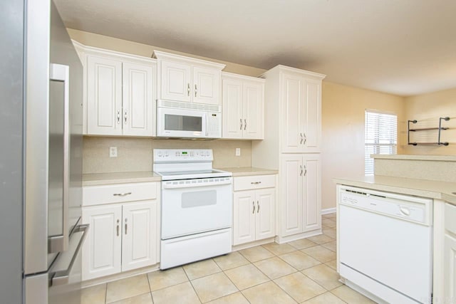 kitchen featuring white appliances, white cabinetry, and light tile patterned flooring