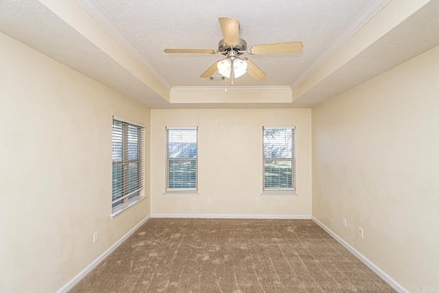 carpeted spare room featuring a textured ceiling, a raised ceiling, crown molding, and ceiling fan