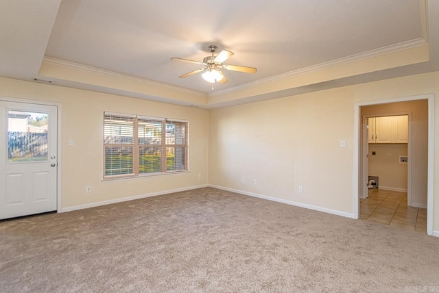 unfurnished room with ceiling fan, a raised ceiling, light carpet, and crown molding