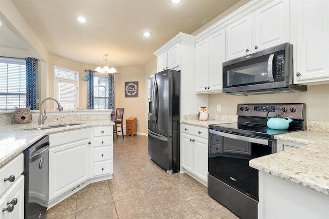 kitchen featuring appliances with stainless steel finishes, hanging light fixtures, white cabinetry, and a notable chandelier