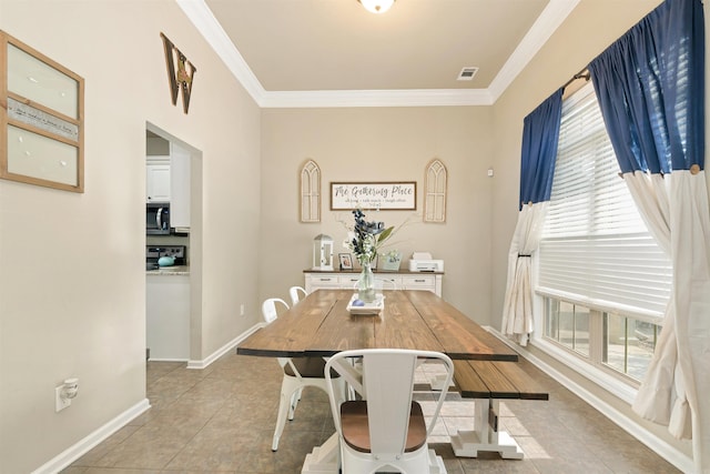 tiled dining room featuring crown molding and a wealth of natural light