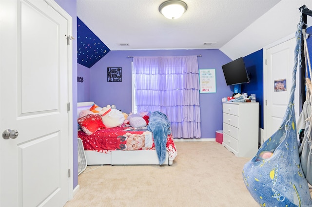 bedroom with light carpet, a textured ceiling, and lofted ceiling