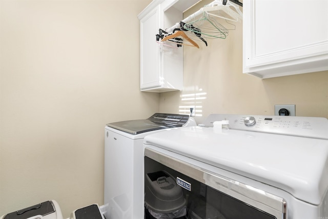 washroom featuring washing machine and clothes dryer and cabinets