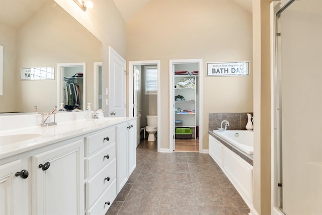 full bathroom with tile patterned flooring, vanity, toilet, and high vaulted ceiling