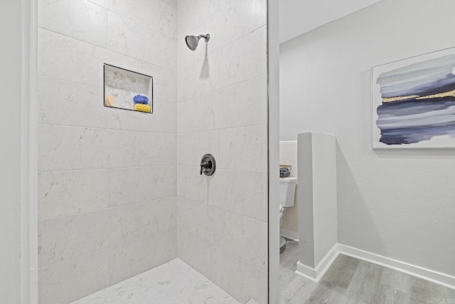 bathroom featuring wood-type flooring and tiled shower