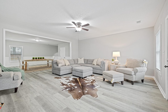 living room with light wood-type flooring and ceiling fan