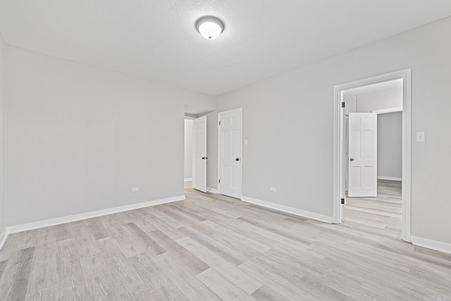 empty room featuring light hardwood / wood-style flooring and a textured ceiling