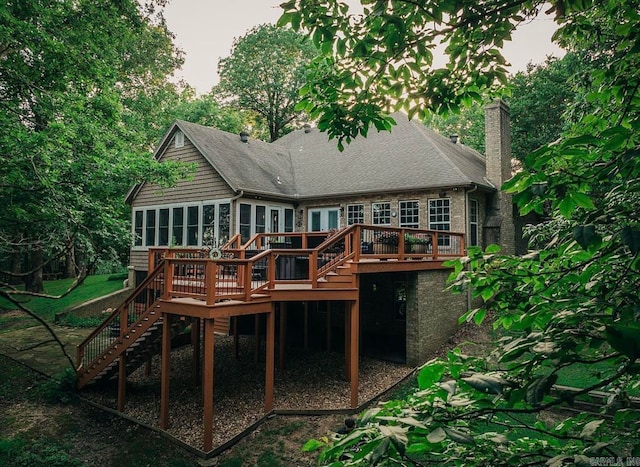 back of property with a sunroom and a wooden deck