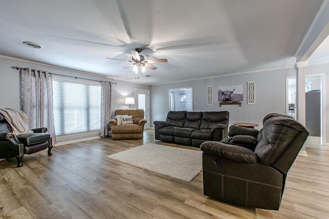 living room with light hardwood / wood-style flooring, ceiling fan, ornamental molding, and ornate columns