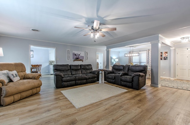 living room featuring ceiling fan, light wood-type flooring, crown molding, and decorative columns