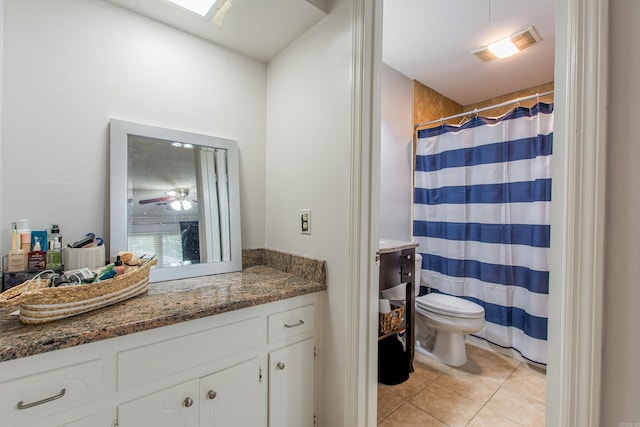 bathroom with vanity, ceiling fan, a skylight, toilet, and tile patterned floors