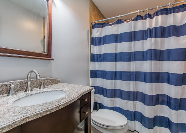 bathroom with walk in shower, vanity, and toilet