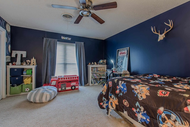 bedroom with ceiling fan, carpet floors, and a textured ceiling