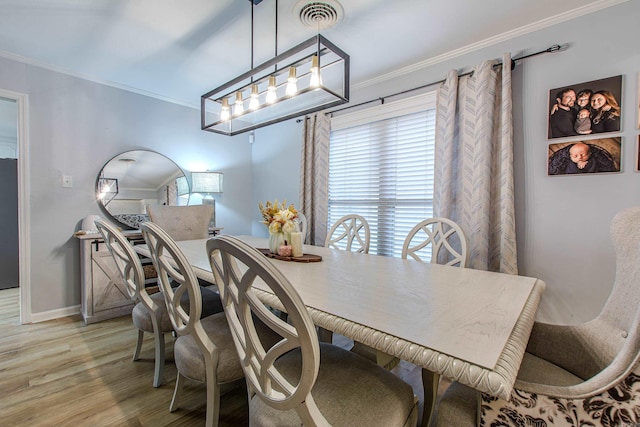 dining room with light hardwood / wood-style flooring, a chandelier, and crown molding