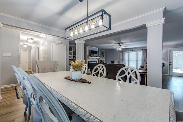 dining area with ceiling fan, ornamental molding, ornate columns, and hardwood / wood-style floors