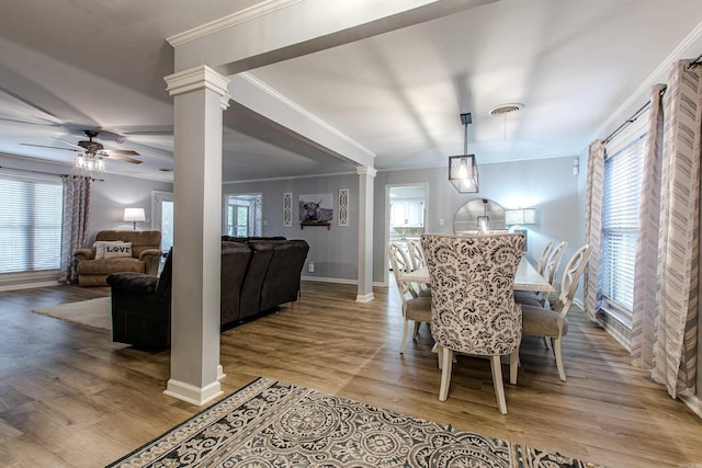 dining area featuring ceiling fan, hardwood / wood-style flooring, decorative columns, and a healthy amount of sunlight