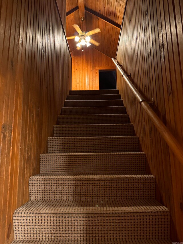 staircase with lofted ceiling, wooden walls, ceiling fan, and wooden ceiling