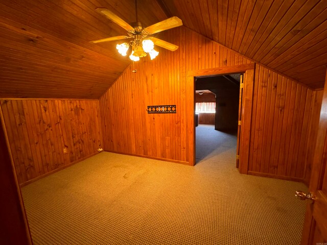 bonus room featuring lofted ceiling, wooden walls, ceiling fan, and wooden ceiling