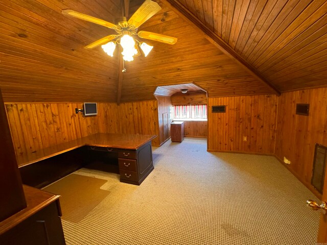 unfurnished office with ceiling fan, wood ceiling, wooden walls, light colored carpet, and vaulted ceiling