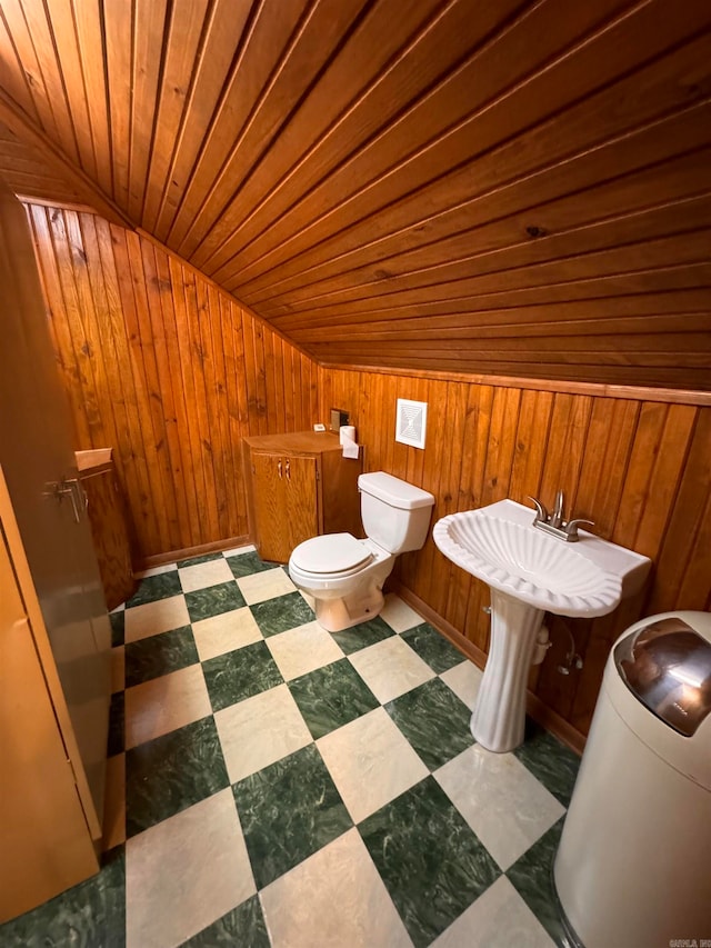 bathroom with wooden ceiling, vaulted ceiling, wooden walls, and toilet