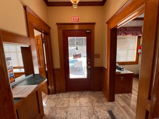 doorway featuring ornamental molding and light hardwood / wood-style flooring