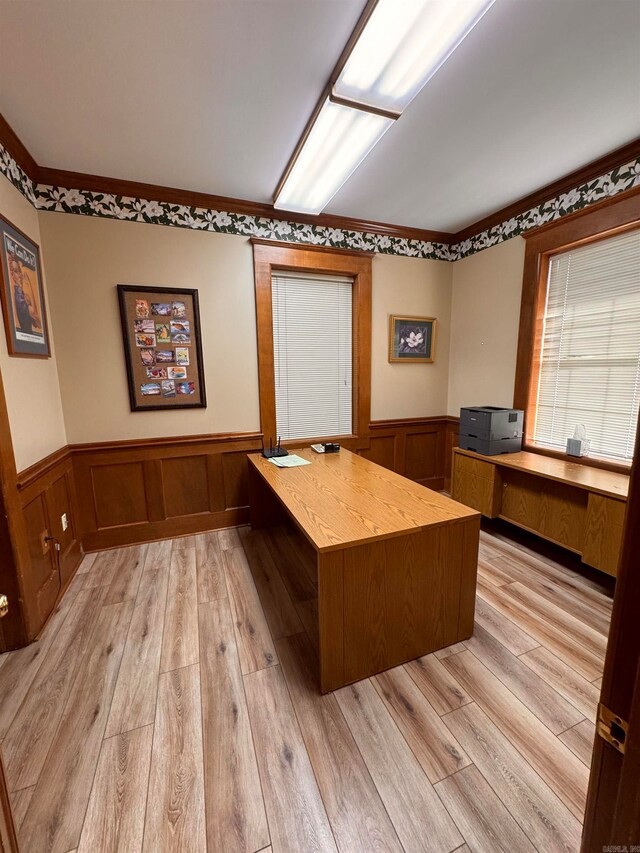 unfurnished office featuring crown molding and light wood-type flooring