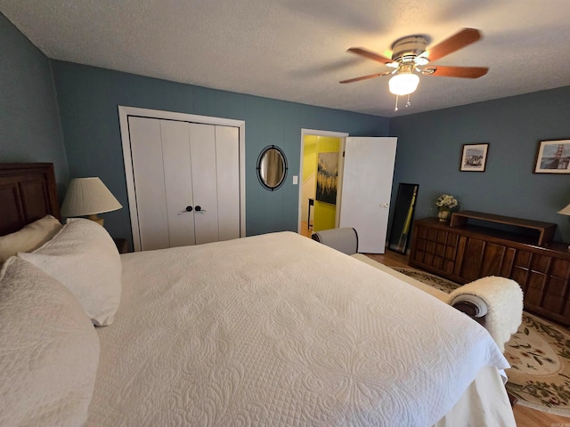 bedroom featuring a textured ceiling, ceiling fan, and a closet