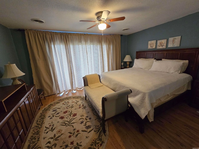 bedroom featuring hardwood / wood-style flooring, ceiling fan, and a textured ceiling