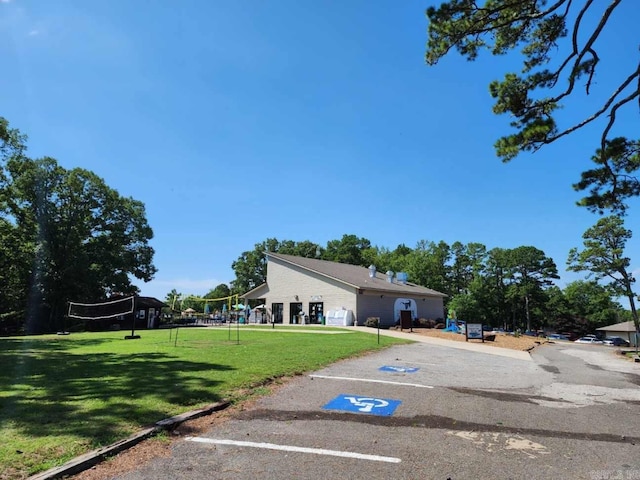 view of front facade featuring a front lawn and volleyball court