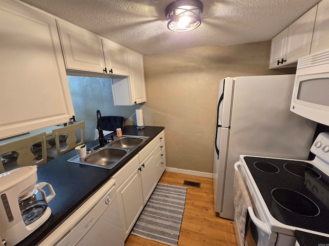 kitchen featuring white cabinetry, a textured ceiling, sink, white appliances, and light hardwood / wood-style flooring