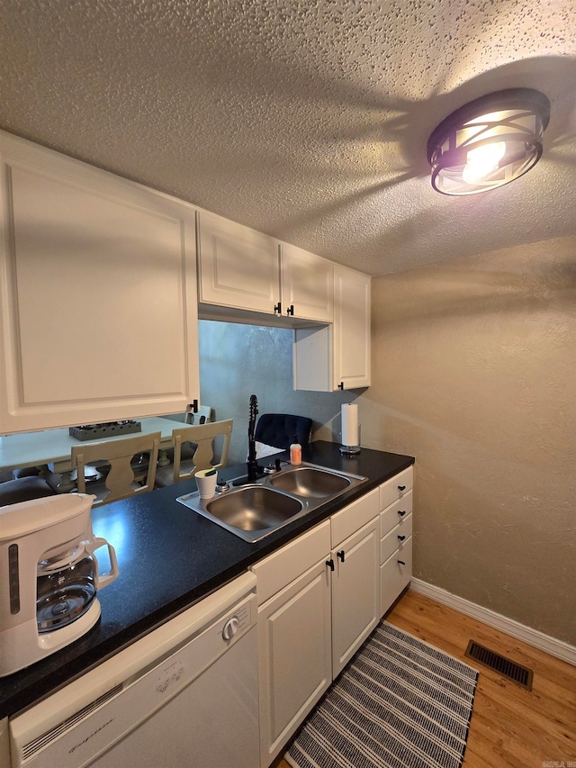 kitchen featuring white cabinets, wood-type flooring, sink, and white dishwasher