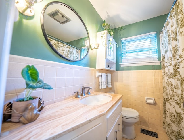 bathroom featuring tile walls, a shower with curtain, tile patterned floors, vanity, and toilet