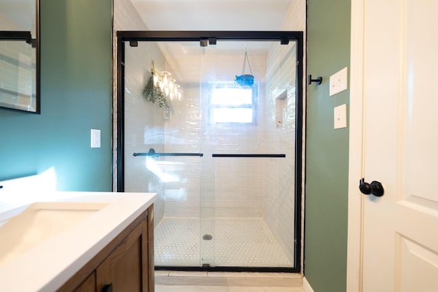 bathroom with a shower with door and vanity