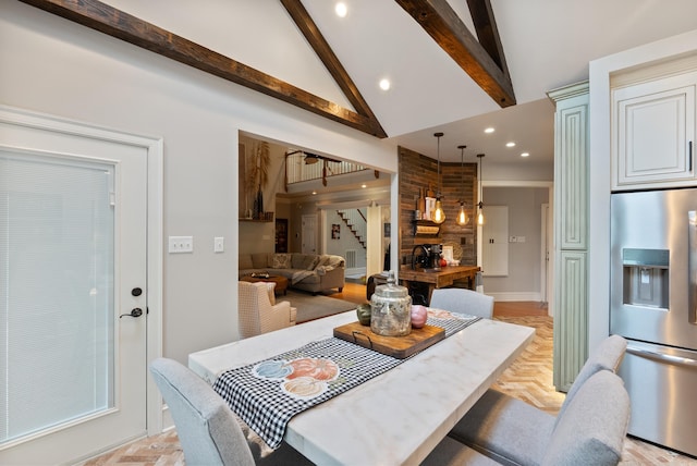 dining space with lofted ceiling with beams