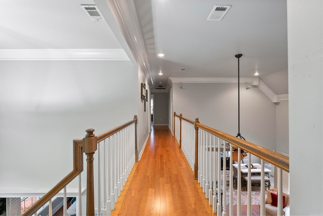 hallway featuring ornamental molding and light wood-type flooring